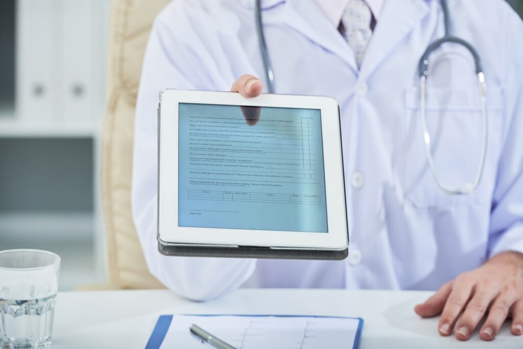 Doctor reviewing a form on a tablet, representing digital healthcare records, efficiency, and modern patient management systems