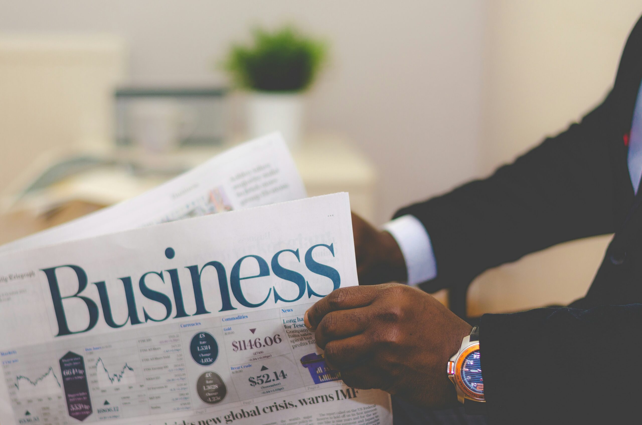 Man reading a business newspaper, representing market insights, economic trends, and informed decision-making.