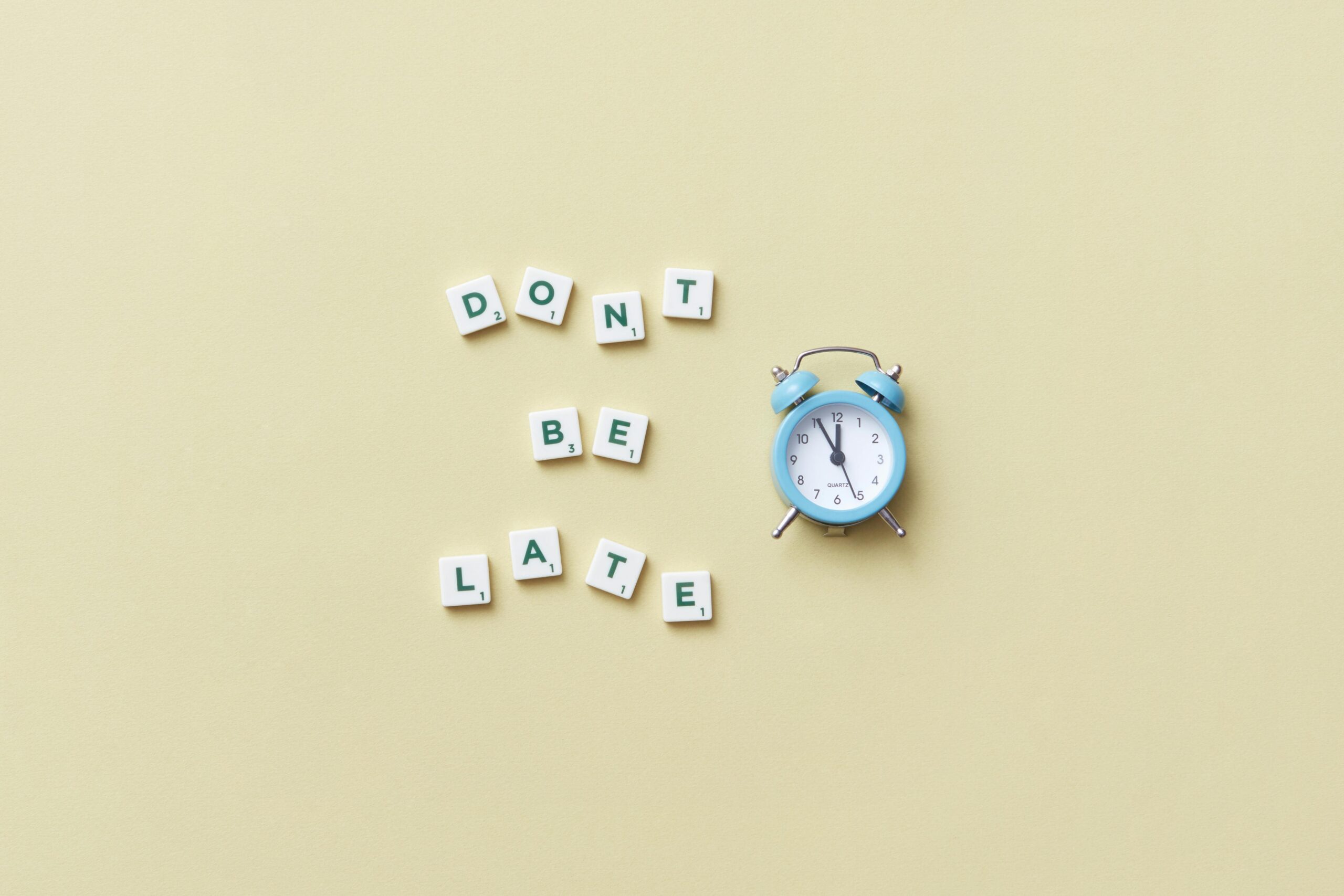 Alarm clock beside text reading “Don’t be late,” representing urgency, deadlines, and time-sensitive business planning.
