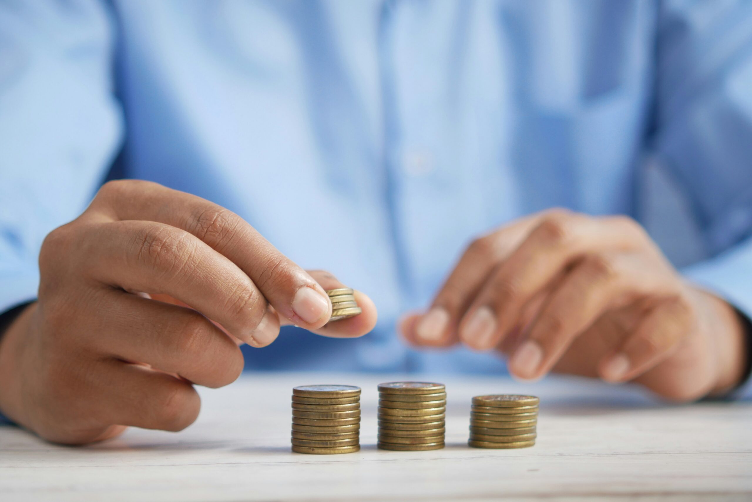 Person counting coins and reviewing finances, representing IT cost optimization, budgeting, and strategic investment planning.