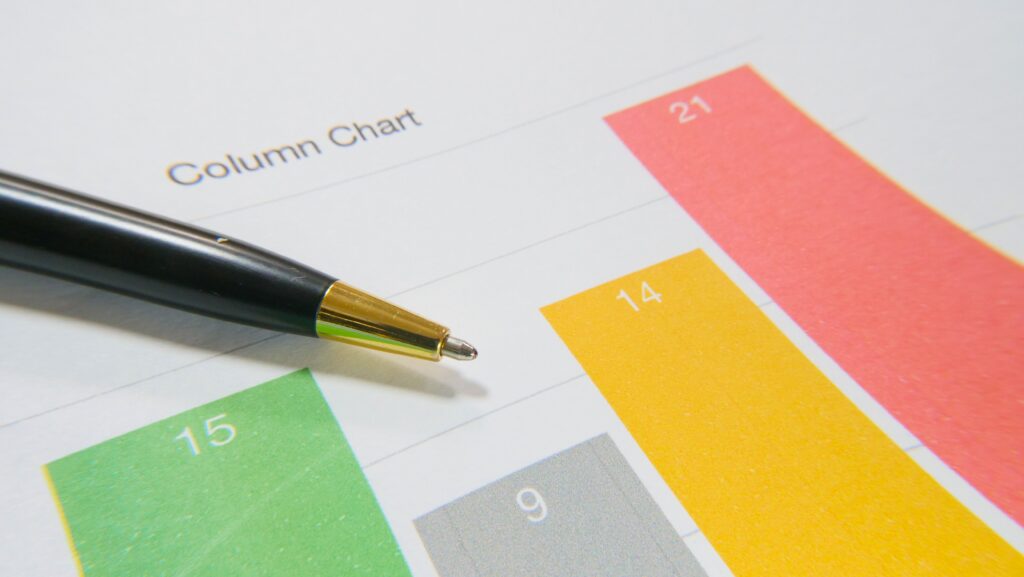 Business report with column charts and a pen, representing data analysis, performance measurement, and strategic planning.