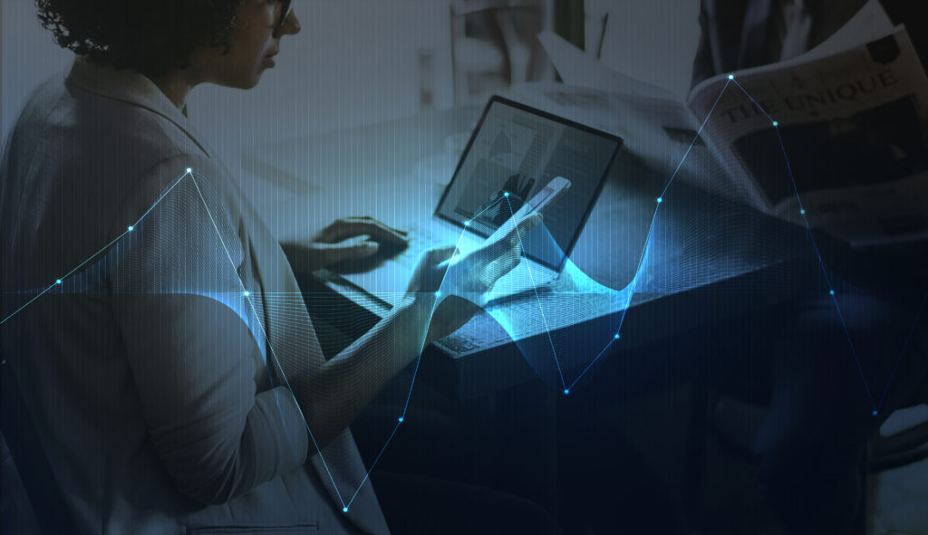 Woman working on a computer with AI and technology graphics, representing AI-enabled workflows and digital transformation