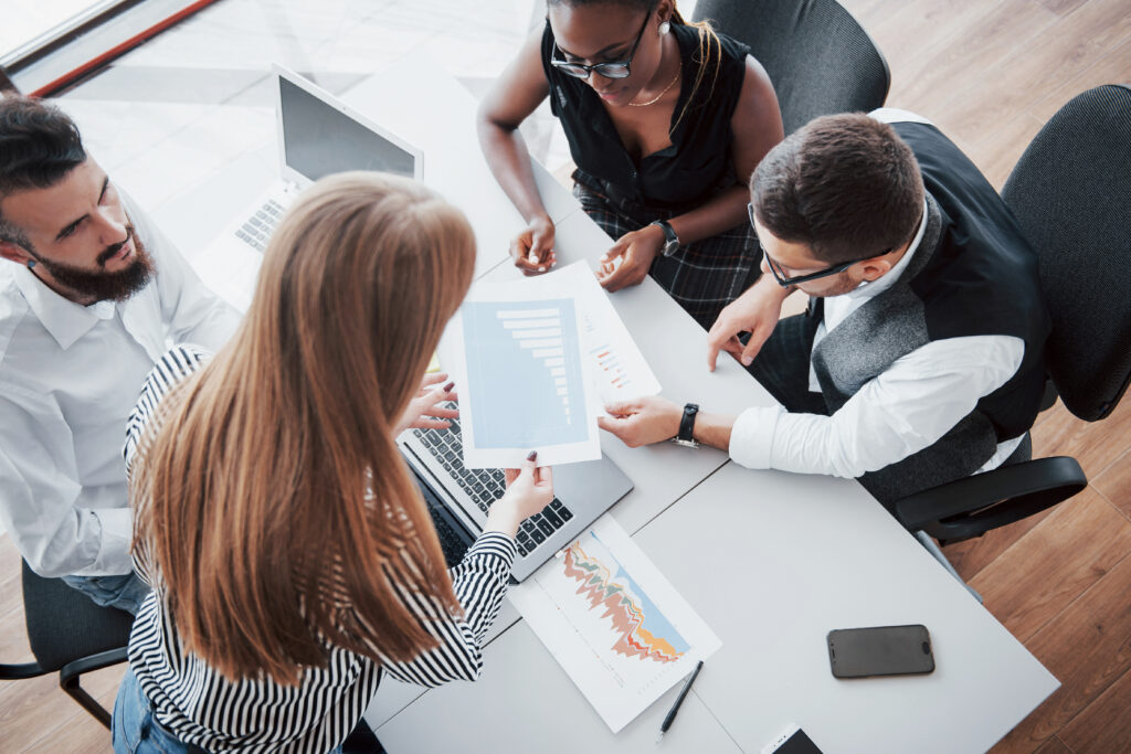 Leadership team collaborating with technology and AI, representing strategic decision-making and AI-driven enterprise transformation